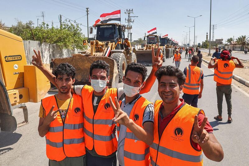 Egyptian workers celebrate after crossing over to Gaza at Rafah border post to help rebuild the enclave following Israeli air strikes. AFP
