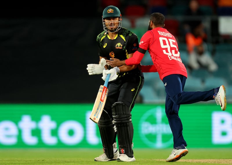 England's Adil Rashid collides with Australia's batsman Marcus Stoinis. AFP