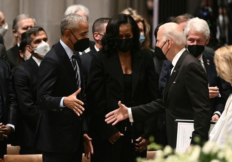 President Biden greets Barack Obama inside the church. AFP
