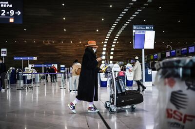 epa08964223 A flight passenger carry luggages at Charles de Gaulle Airport, in Roissy, outside Paris, France, 25 January 2021. France is now imposing a negative Covid-19 test for European commuters to curb the spread of the coronavirus pandemic.  EPA/YOAN VALAT