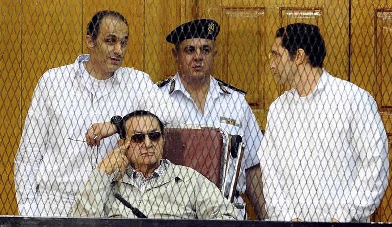 Hosni Mubarak and his two sons Gamal Mubarak, left, and Alaa Mubarak attend a hearing in Cairo on Saturday. Ahmed Omar / AP Photo