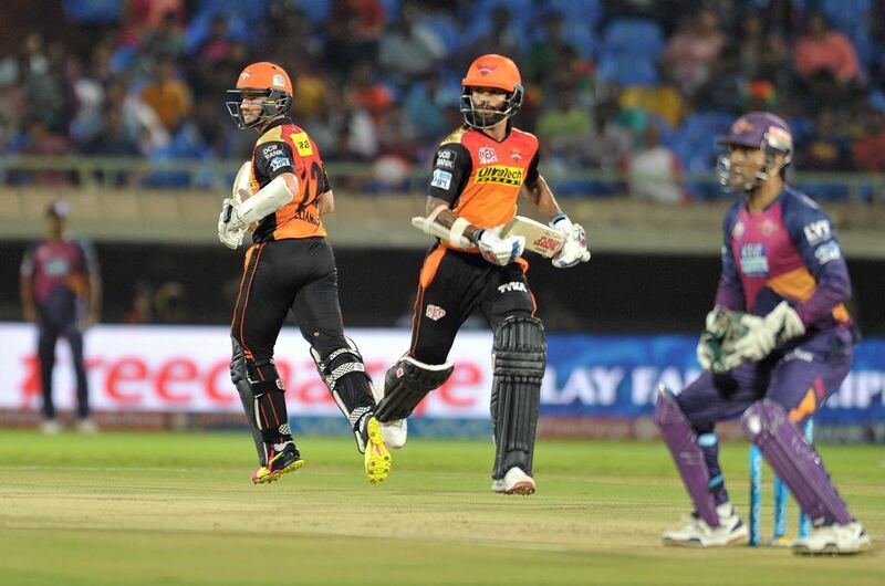 Sunrisers Hyderabad batsman Shikhar Dhawan, right, and Kane Williamson run between the wickets as Rising Pune Supergiants wicketkeeper MS Dhoni, right, looks on. Noah Seelam / AFP