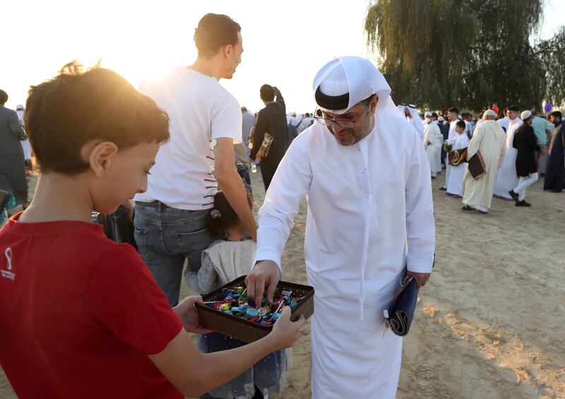 A child offers sweets after Eid morning prayers in Al Barsha. Chris Whiteoak / The National