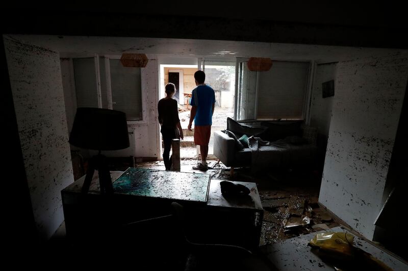 Two people look at a damage house. EPA