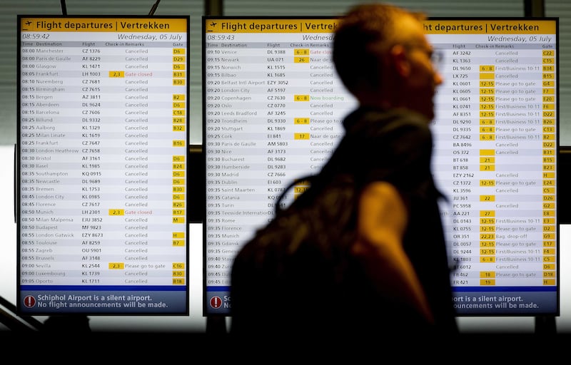 A traveller checks an information board at Schiphol Airport. EPA