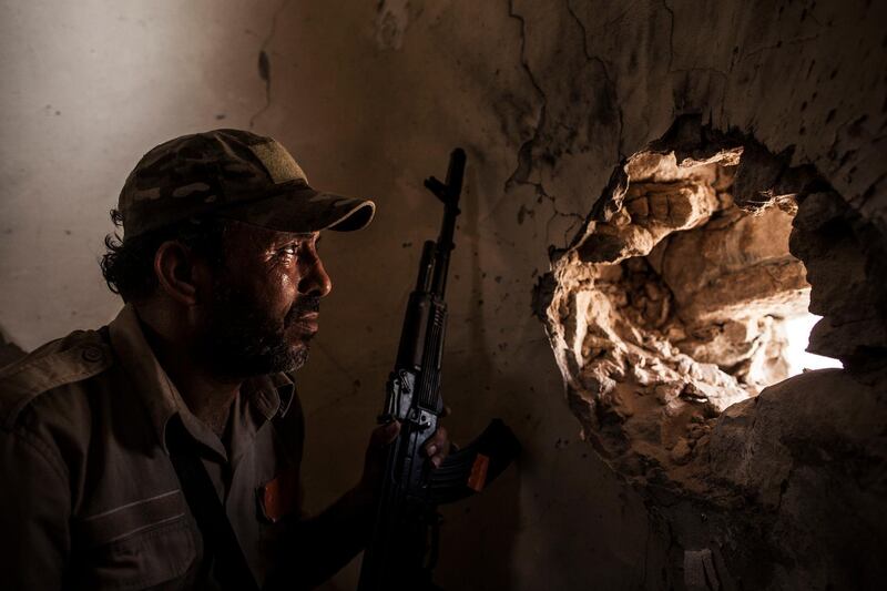 FILE - In this Sept. 22, 2016, file photo, a fighter of the Libyan forces affiliated to the Tripoli government scans for targets from the minaret of a mosque in Sirte, Libya. The warring parties in Libya and their international backers â€” the United Arab Emirates, Russia and Jordan vs Turkey and Qatar â€” violated a U.N. arms embargo on the oil-rich north African country that remains â€œtotally ineffective,â€ U.N. experts said in a new report. (AP Photo/Manu Brabo, File)