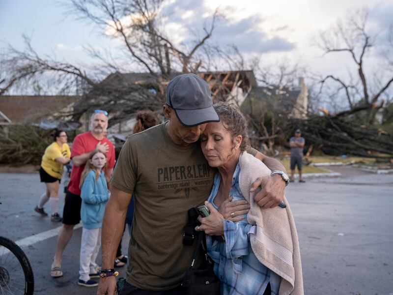 Michael Talamantez comforts his girlfriend Derry Schroer after Talamantez' house on Stratford Drive in Round Rock, Texas was destroyed by a severe storm, reported as a tornado, while they were inside on Monday March 21, 2022.  "I thought I was going to die," he said.  (Jay Janner / Austin American-Statesman via AP)