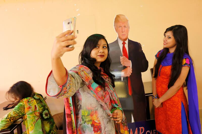 epa06082934 Customers take selfie with cutout resembling US president Donald Trump at the Trump Cafe situated at Zigatola in Dhaka, Bangladesh, 12 July 2017. US president Donald Trump has got an unusual presence in Bangladesh as one of his diehard fans opened a cafe under his name in capital Dhaka. The Trump Cafe, which was opened in April in Dhaka's Zigatola has slowly becoming a popular hangout spot for his Bangladeshi fans.  EPA/ABIR ABDULLAH