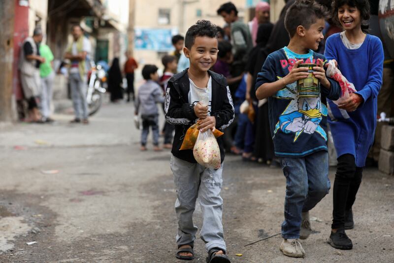 Boys leave after receiving meals from a charity kitchen in Sanaa.