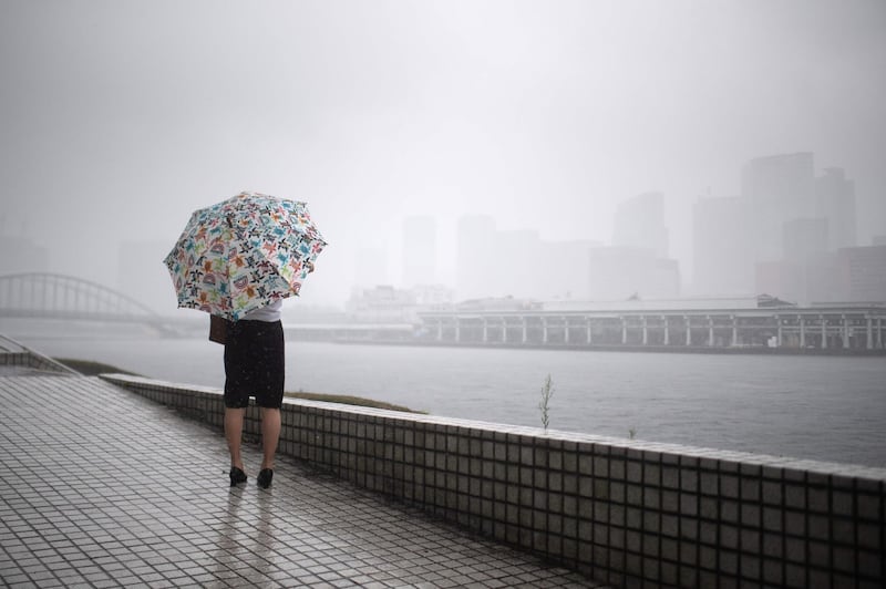 A woman protects herself from the rain with an umbrella in Tokyo.  AFP / Martin BUREAU