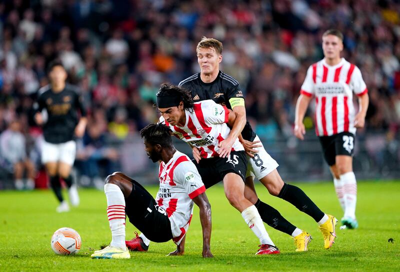 Arsenal's Martin Odegaard and PSV's Erick Gutierrez battle for the ball. PA