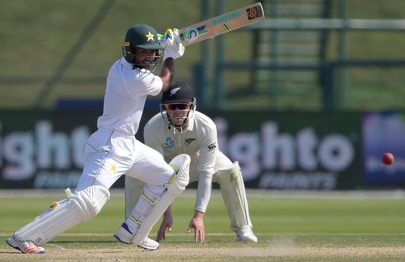 Pakistani batsman Asad Shafiq (L) plays a shot as New Zealand cricketers Henry Nicholls looks on during the fourth day of the first Test cricket match between Pakistan and New Zealand at the Sheikh Zayed International Cricket Stadium in Abu Dhabi on November 19, 2018.  / AFP / AAMIR QURESHI
