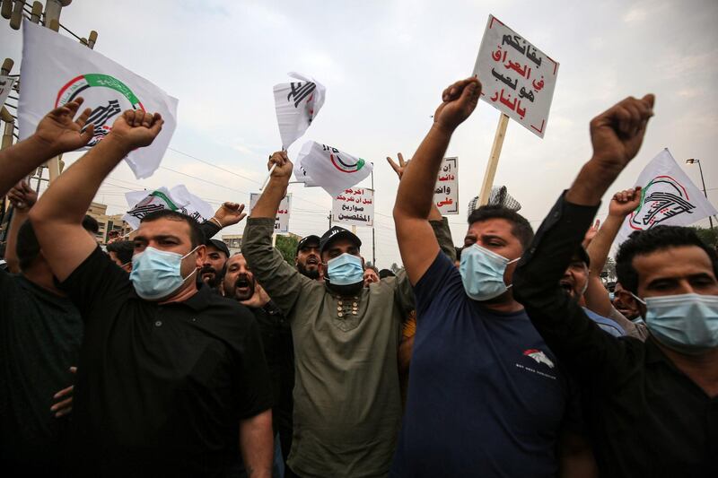 Supporter of the Iran-backed Hashed al-Shaabi (Popular Mobilisation) paramilitary forces chant slogans during a demonstration outside the entrance to the Iraqi capital Baghdad's highly-fortified Green Zone on November 7, 2020, demanding the departure of remaining US forces from Iraq. Several hundred protesters gathered in the Iraqi capital on Saturday afternoon to demand US troops leave the country in accordance with a parliament vote earlier this year. / AFP / AHMAD AL-RUBAYE
