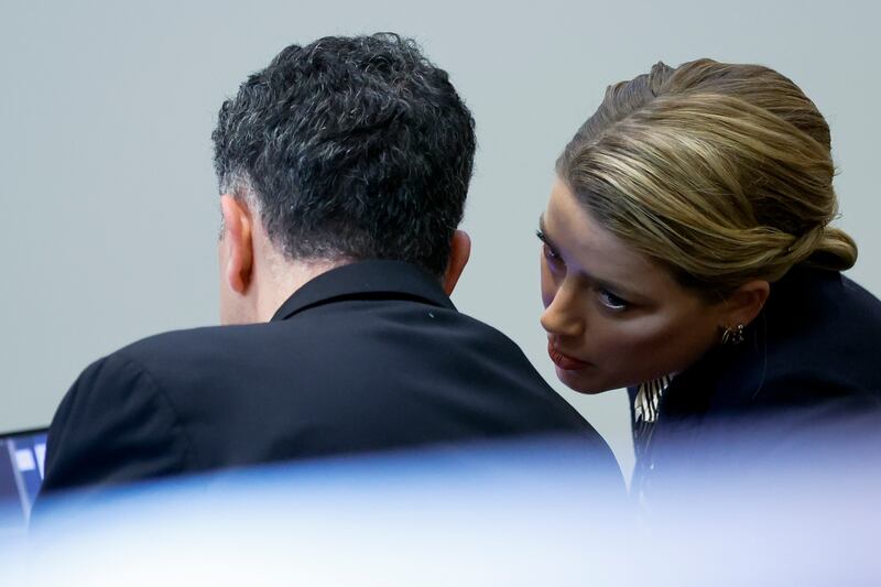 Heard speaks to a member of her legal team in the court in Virginia. EPA