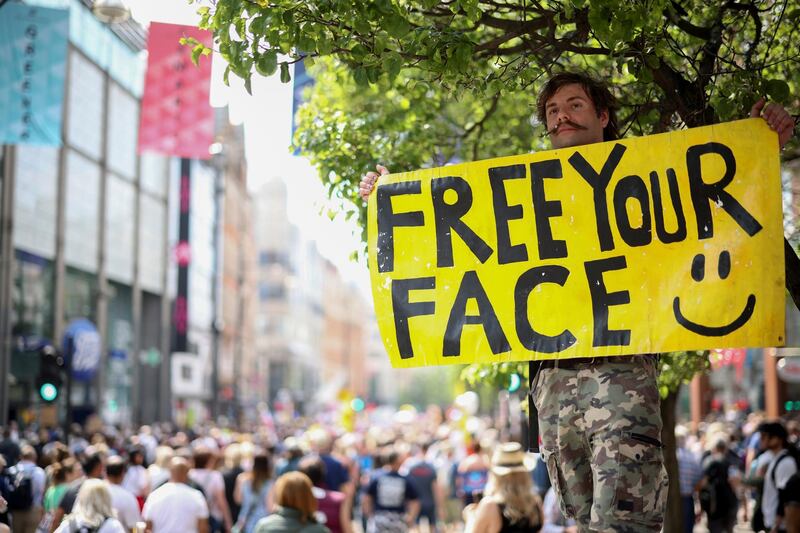 A demonstrator holds a placard during an anti-lockdown and anti-vaccine protest in London. Reuters