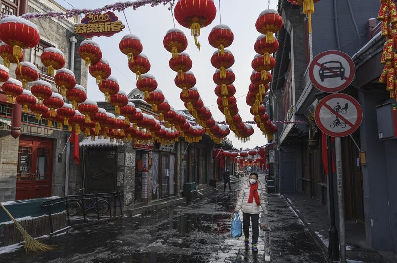 BEIJING, CHINA - FEBRUARY 07: A Chinese woman wears a protective mask as she walks in a nearly empty and shuttered commercial street on February 7, 2020 in Beijing, China. The number of cases of a deadly new coronavirus rose to more than 31000 in mainland China Friday, days after the World Health Organization (WHO) declared the outbreak a global public health emergency. China continued to lock down the city of Wuhan in an effort to contain the spread of the pneumonia-like disease which medical experts have confirmed can be passed from human to human. In an unprecedented move, Chinese authorities have put travel restrictions on the city which is the epicentre of the virus and municipalities in other parts of the country affecting tens of millions of people. The number of those who have died from the virus in China climbed to over 636 on Friday, mostly in Hubei province, and cases have been reported in other countries including the United States, Canada, Australia, Japan, South Korea, India, the United Kingdom, Germany, France and several others. The World Health Organization has warned all governments to be on alert and screening has been stepped up at airports around the world. Some countries, including the United States, have put restrictions on Chinese travellers entering and advised their citizens against travel to China. (Photo by Kevin Frayer/Getty Images)