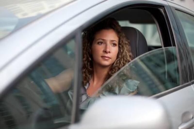 June 9, 2011 - Yasmin Dahleh poses for a portrait in her car in Abu Dhabi. Dahleh travels from Dubai to Abu Dhabi for work everyday and along with sitting for long periods of time at work is suffering from back pain. Pawel Dwulit / The National
