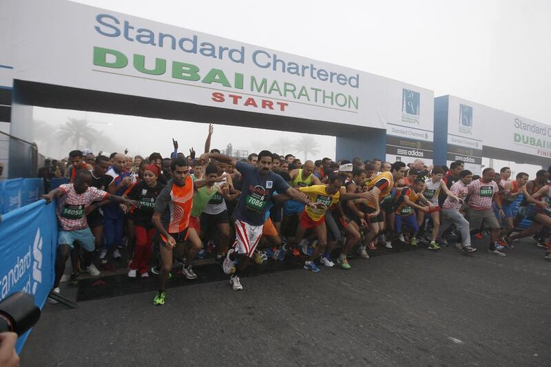Under an early-morning fog, runners start the Dubai Marathon 10km race last year. More than 20,000 are expected to compete in three different categories tomorrow. Mike Young / The National

