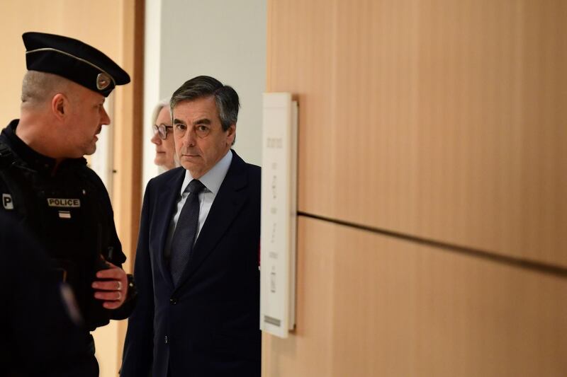 TOPSHOT - Former French Prime minister Francois Fillon (R) arrives at Paris' courthouse, on February 26, 2020, for the opening hearing of his trial along with his wife Penelope over claims they embezzled over one million euros in an alleged fake-jobs fraud.
 Investigators suspect that Fillon, 65, hired his Welsh-born wife Penelope as his parliamentary assistant between 1998 and 2013, without having her do any actual work. / AFP / Martin BUREAU
