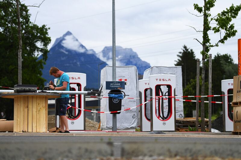 A technician works on solar-powered lamp-posts at a Tesla charging site in Niederbreitenbach, Austria. Bloomberg