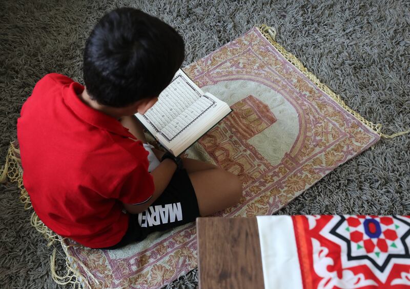Mazen reads the Quran at home in Mira, Dubai.