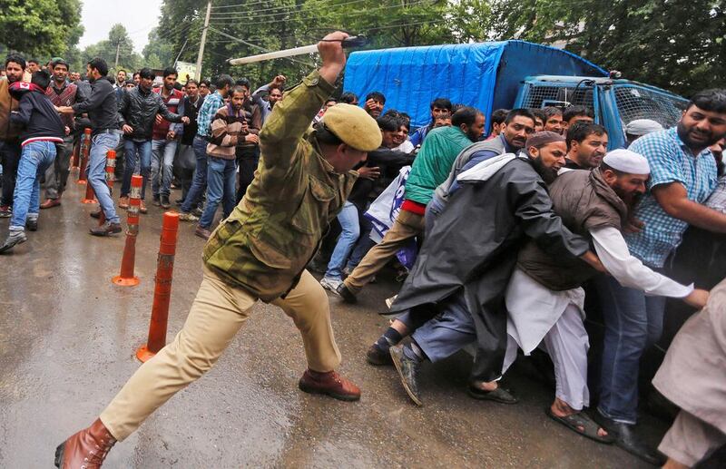 A policeman uses a baton to disperse demonstrators during a protest by government employees demanding their long pending arrears in Srinagar.  Danish Ismail / Reuters