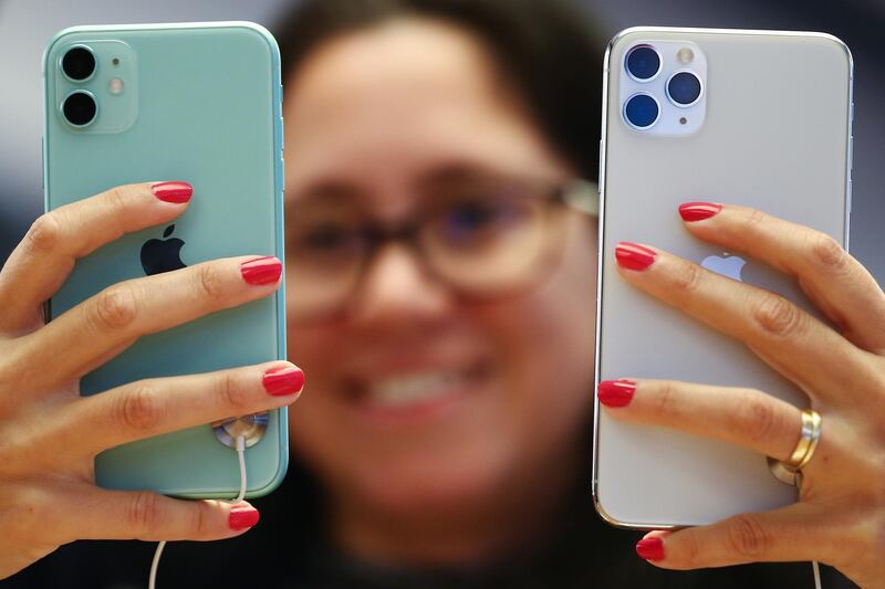 An attendee holds Apple Inc. iPhone 11, left, and iPhone 11 Pro smartphones at an Apple store in Sydney, Australia. Bloomberg