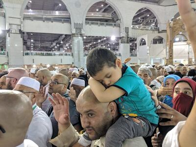 A little boy rides on his father’s shoulders