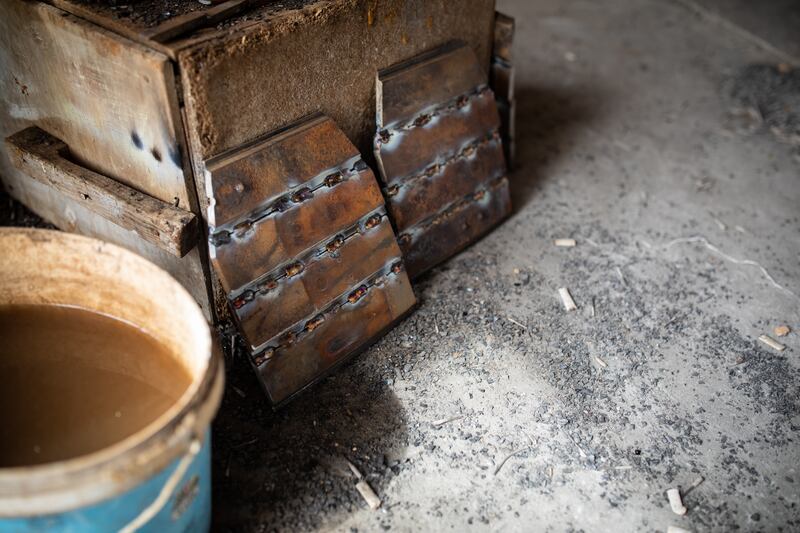 Freshly welded steel plates sit on the ground cooling before being covered in foam and duct tape. The plates are inserted into vests and sent to Ukrainian forces fighting the Russian invasion of their country.