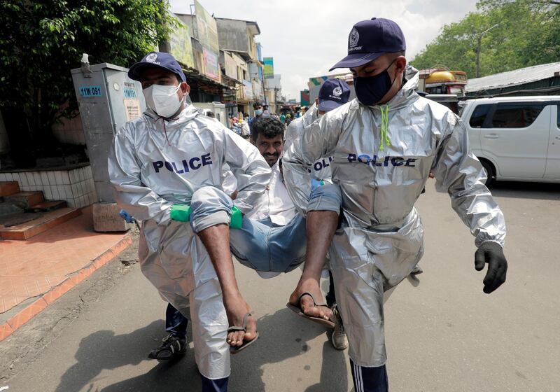 Police officers in Colombo, Sri Lanka, detain a person near a main market for not wearing a mask, breaking Covid-19 rules and regulations. Reuters