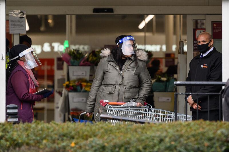 LONDON, UNITED KINGDOM - JANUARY 12: A security guard (R) assists a member of the store team as they stand at the entrance to a branch of the Sainsbury's supermarket chain following the company's decision to enforce the mandatory wearing of face masks in their stores, on January 12, 2021 in London, United Kingdom. In response to government ministers voicing concerns about the public's behaviour in supermarkets, Sainsbury's and Morrisons have both announced they will be enforcing rules on mask-wearing in their stores. The daily admissions to hospitals of coronavirus cases  has topped 4000 and the current number of patients in hospital with the virus is 32,294. (Photo by Leon Neal/Getty Images)