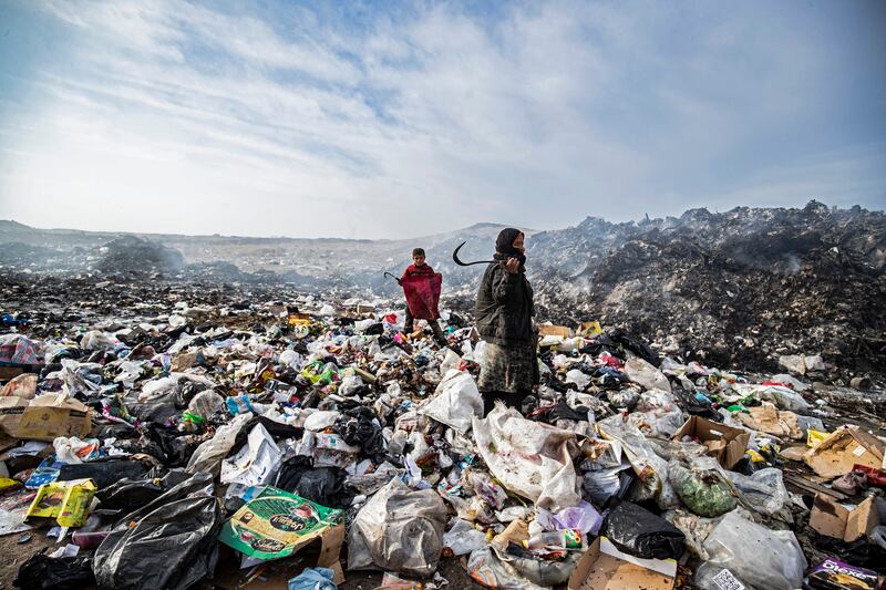 Syrians sift through a garbage dump near an oil field in the countryside of Malikiya in north-east Syria. AFP