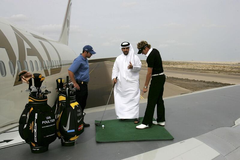 ABU DHABI, UNITED ARAB EMIRATES - JANUARY 18: Ian Poulter of England and Paul Casey of England give an impromptu golf lesson to Etihad passenger Khalie Al Shamsi of the UAE as they signal take-off for their Ryder Cup campaigns as they hit drives from the wing of an Etihad Boeing 767 on the runway at the Abu Dhabi International Airport on January 18, 2006 in Abu Dhabi, United Arab Emirates. Poulter outdrove Casey from the wing with an unoffical drive of 696 yards against Casey's best of 689 yards. The drive was the longest ever recorded in the Middle East and Asia and was an opening preview for the Etihad co-sponsored Abu Dhabi Golf Championship on the National Course at Abu Dhabi Golf Club. (Photo by David Cannon/Getty Images for Etihad Airways)