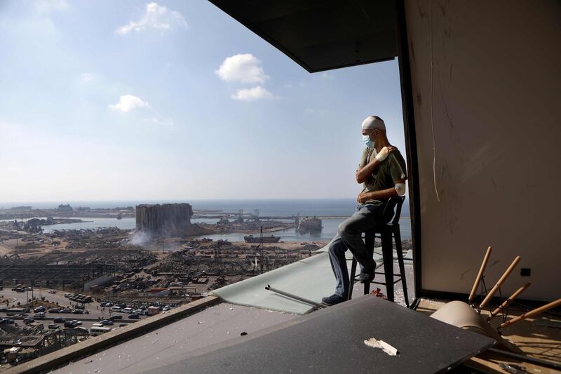 Lebanese TV producer Tony Ahwaji sits injured on the balcony of his damaged apartment in the damaged neighbourhood of Mar Mikhael in Beirut. AFP