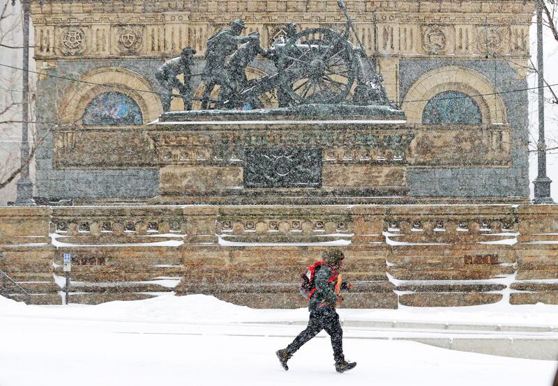 A pedestrian races to catch his bus amid driving snow in central Cleveland, Ohio. AP