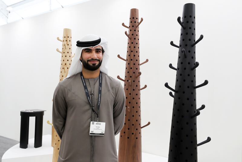 Emirati designer Omar Al Gurg at Downtown Design with his wooden stands that can be used to hang clothes and hats