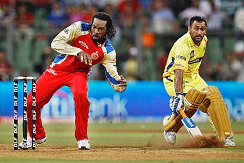 Royal Challengers Bangalore’s Chris Gayle, left, makes an attempt to run out Chennai Super Kings’ captain MS Dhoni, right, during last night’s thrilling game.