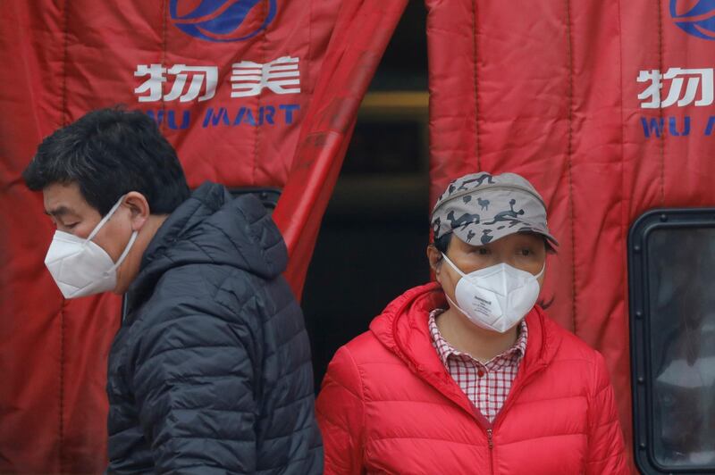 People wearing protective masks walk out of a supermarket in Beijing, China, with over 60,000 infected worldwide, mostly in China.  EPA
