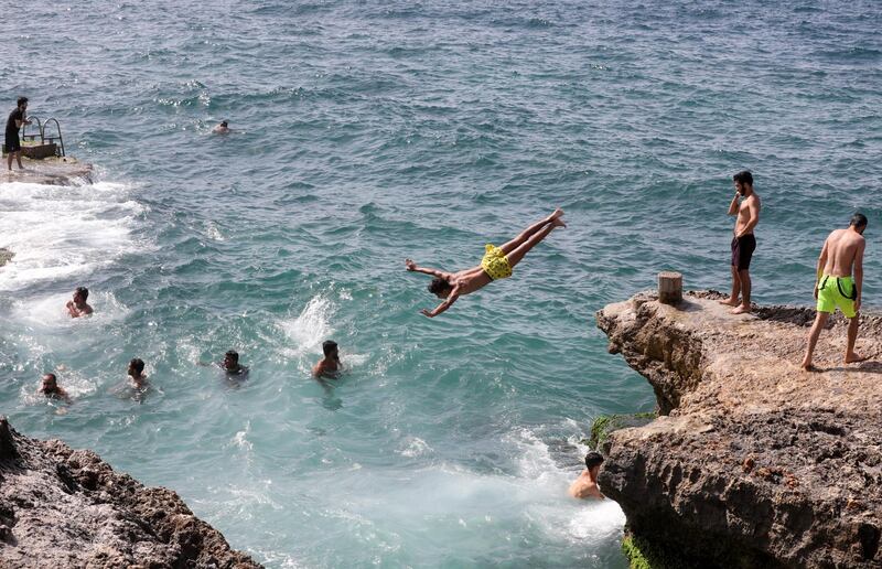 People swim in the sea, as Lebanon is gradually reopening its economy. REUTERS