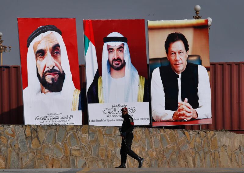 A police commando walks past the huge billboards showing the portraits of Abu Dhabi's Crown Prince, Sheikh Mohammed bin Zayed Al Nahyan, center, former President of the United Arab Emirates Sheikh Zayed bin Sultan Al Nahyan, left, and Pakistani Prime Minister Imran Khan to welcome crown prince to Islamabad, Pakistan, Sunday, Jan. 6, 2019. Abu Dhabi's crown prince is in Islamabad on daylong trip to discuss bilateral, International and regional issues with Pakistani leadership. Prince likely to announce billions to help Pakistani economy stabilized during visit. (AP Photo/Anjum Naveed)