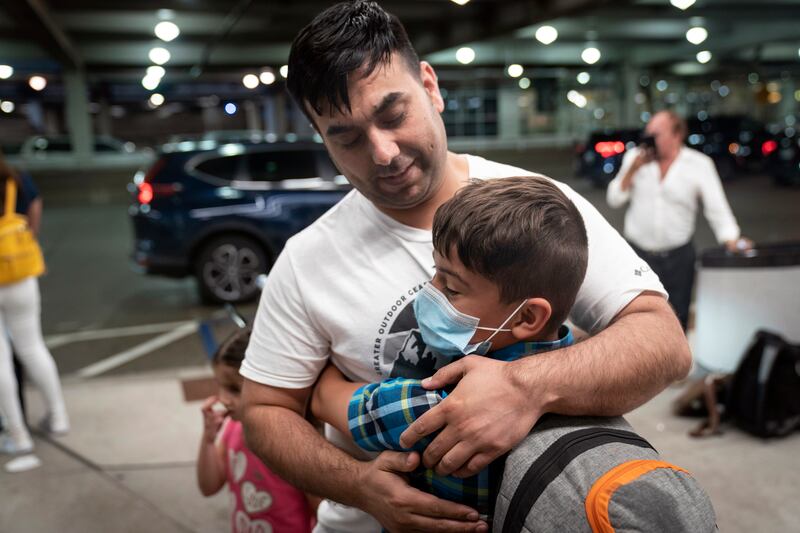 Ziaullah Qazizada embraces his son, Mesbahullah, at Minneapolis-Saint Paul International Airport in the US state of Minnesota. The 10-year-old had been stuck in Afghanistan after travelling to visit family in July. AP