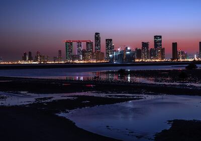 Al Jeel Towers lit up in UAE colours at Al Reem Island, as seen from Saadiyat Island, Abu Dhabi. Victor Besa / The National.