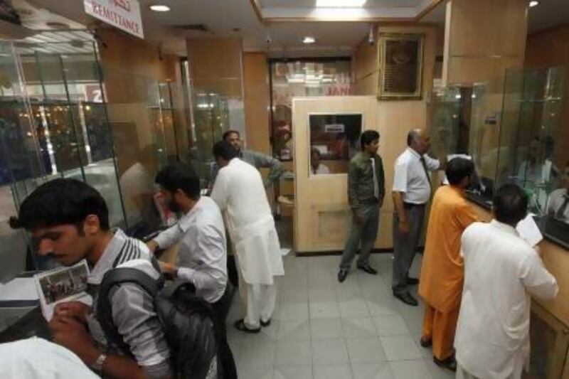 Pakistani workers in the UAE sending money home at an exchange centre. They are to be offered loans try to boost the total. Jeffrey E Biteng / The National