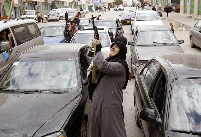 A woman fires an AK-47 rifle as she reacts to the news of the withdrawal of Libyan leader Muammar Gaddafi's forces from Benghazi on March 19, 2011. Goran Tomasevic / Reuters