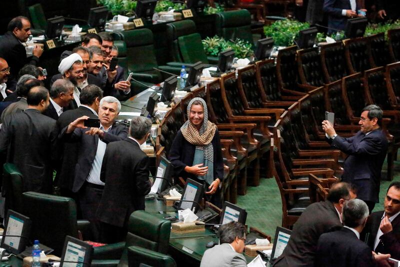 Former Iranian foreign ministry spokesman Hassan Ghashghavi, right, uses a cell phone to take a picture of EU foreign policy chief Federica Mogherini standing together with Iranian MPs after the conclusion of the swearing in ceremony of the Iranian president before parliament in Tehran. AFP