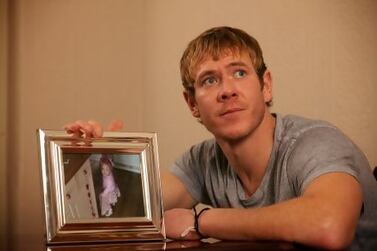 Dean Holden with a photograph of his daughter, Cici Milly, who died from illness on a family holiday in the Canary Islands.