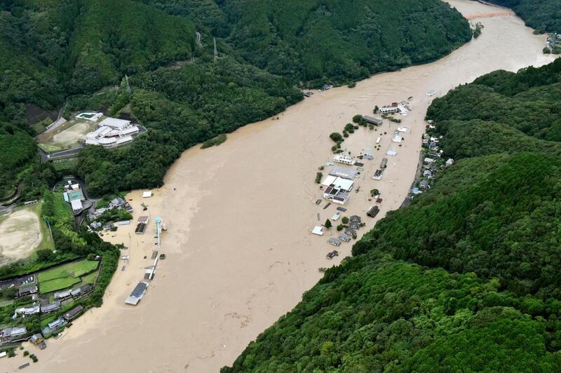 This aerial view shows the Kuma River swollen by heavy rain in Yatsushiro, Kumamoto prefecture. Kyodo News via AP