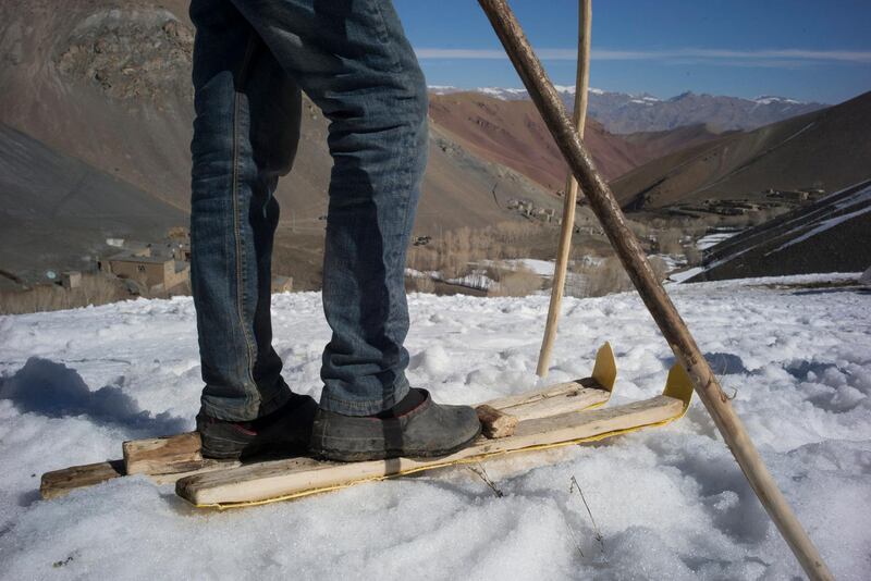 AFGHANISTAN, Bamiyan: 04 March 2021
Pictures from the annual Afghan Mountain Challenge - a ski event held in Bamiyan Province, 80 miles west of Kabul. Participants have to run up the mountain via specific checkpoints and then proceed to ski down. 
Pictured - A local boy shows off his wooden skis and poles. Rick Findler for The National