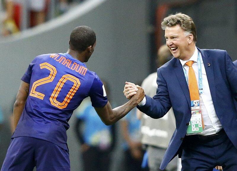 Georginio Wijnaldum of the Netherlands, left, celebrates with coach Louis van Gaal after scoring his team's third goal against Brazil during their 2014 World Cup third-place playoff at the Brasilia national stadium in Brasilia July 12, 2014. Van Gaal starts his new job at Manchester United on Wednesday. REUTERS/Dominic Ebenbichler