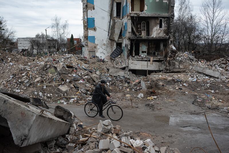 Valerii, 65, rides by his destroyed apartment building in Borodianka. Getty Images